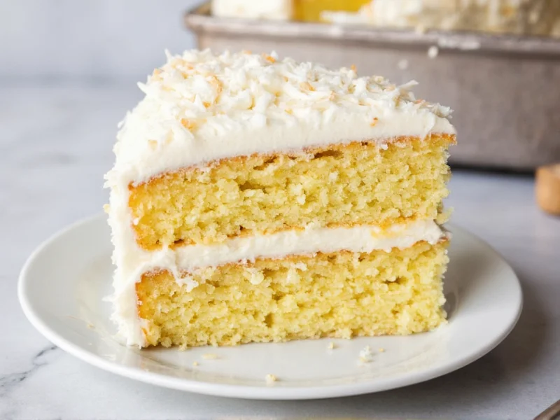 Moist homemade coconut cake with fluffy frosting on plate