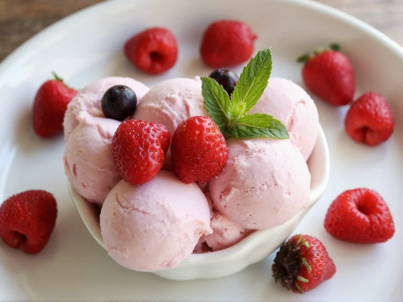 Serving of homemade ice cream with fresh berries and mint garnish