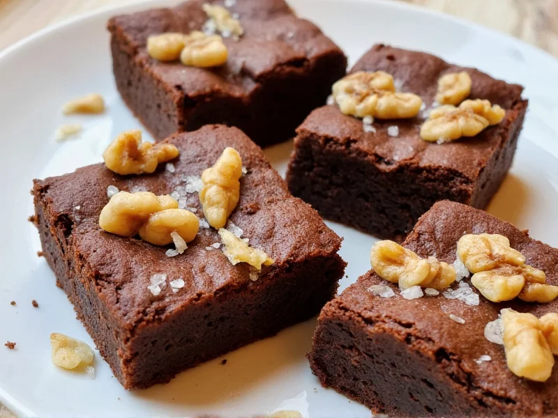Homemade brownies topped with flaky sea salt and walnut pieces