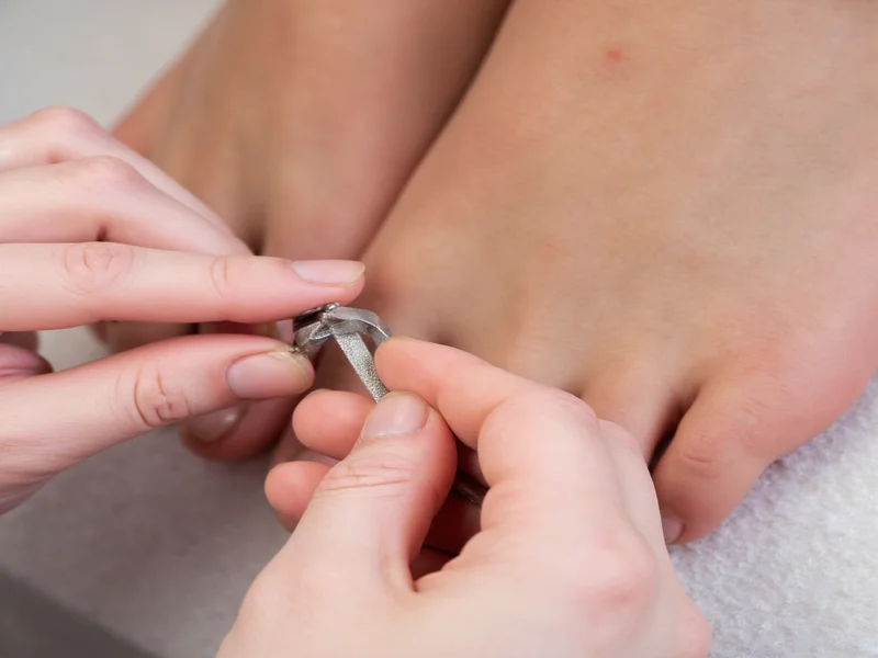 Hands demonstrating proper toenail filing technique