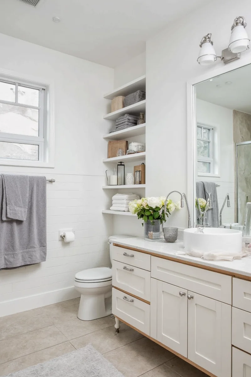 Floating over-the-toilet shelves storing towels and toiletries