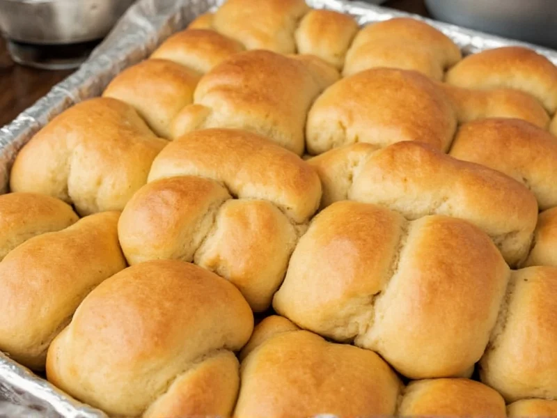 Golden homemade hawaiian bread rolls on baking sheet
