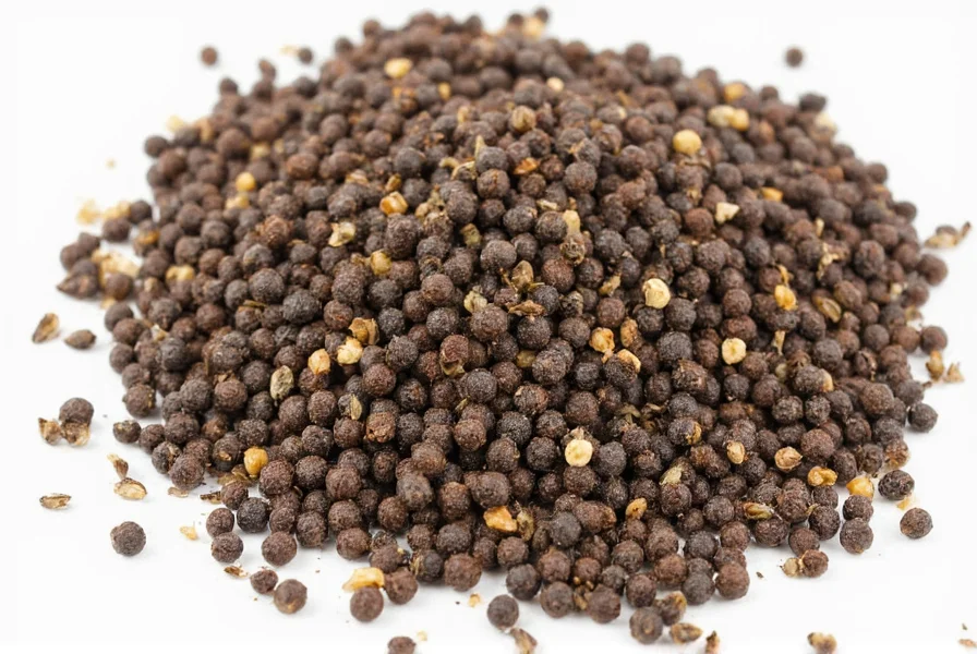 Measuring spoons with black peppercorns, garlic powder, and paprika for homemade blackened seasoning