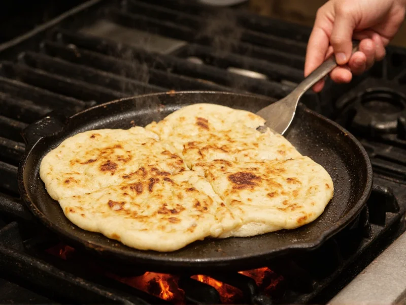 Homemade naan cooking on cast iron skillet