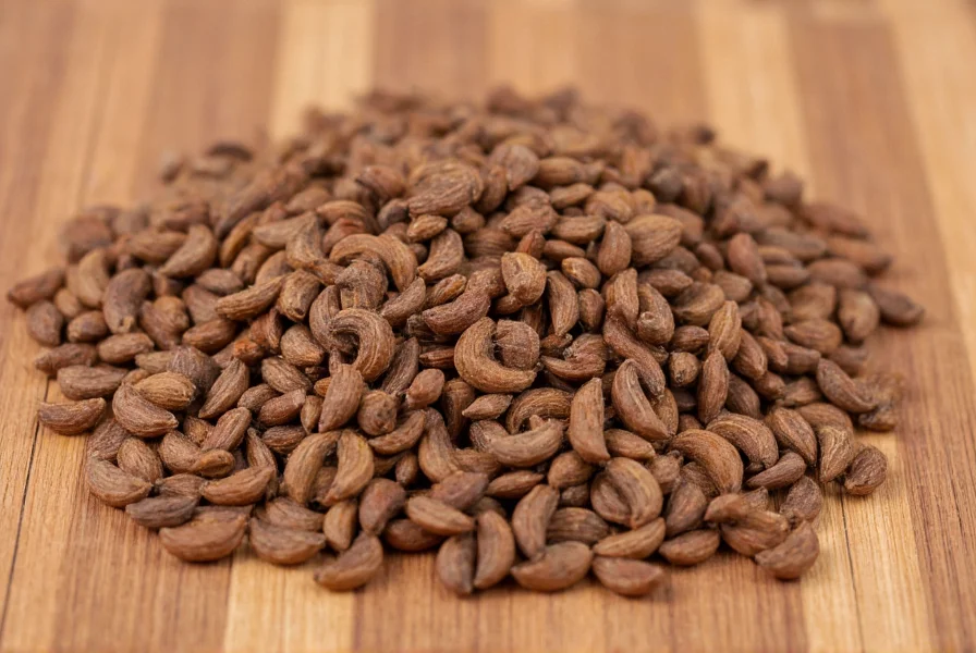Close-up photograph of cumin seeds showing their distinctive crescent shape and brown color on a wooden background