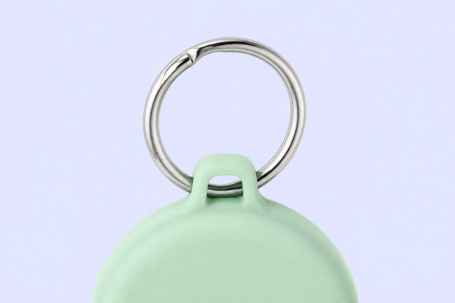 Close-up of the polished silver split ring on a mint green tag