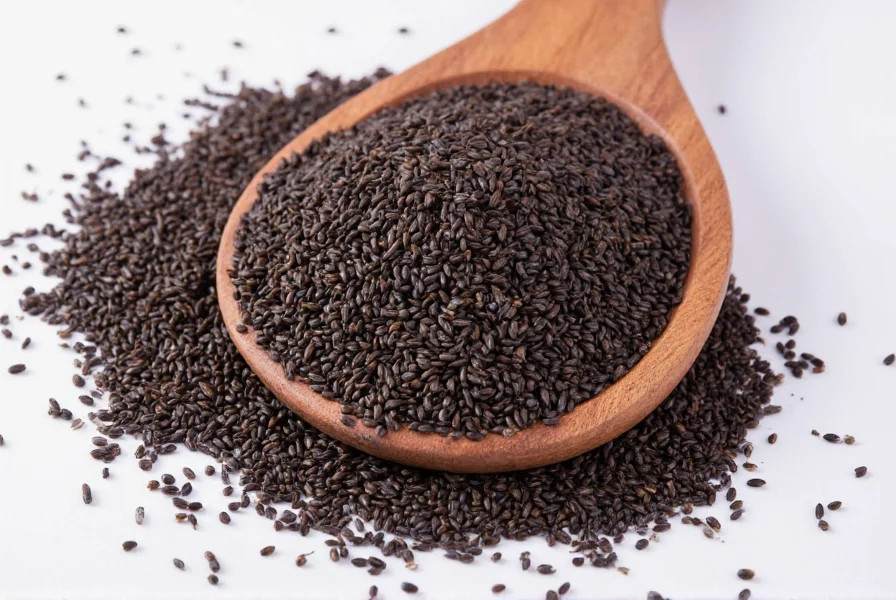 Black cumin seed oil bottle with measuring dropper on wooden background