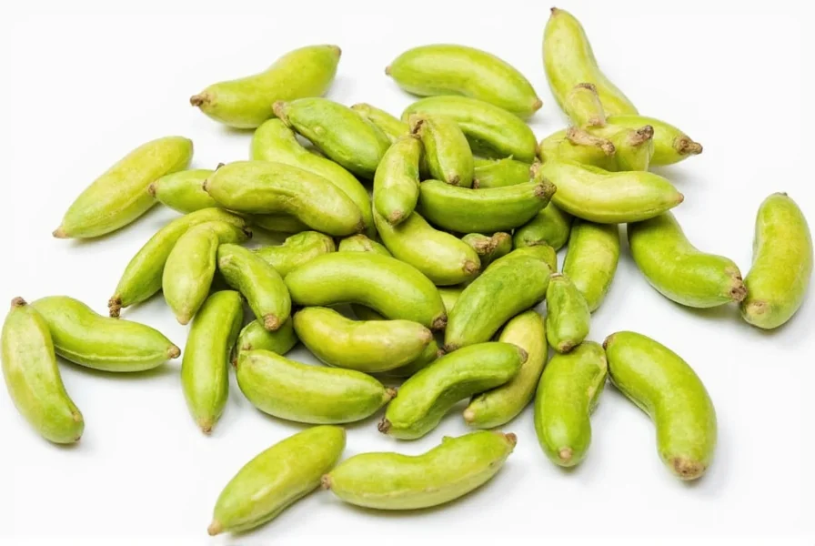 Close-up view of green and black cardamom pods side by side showing color and size differences