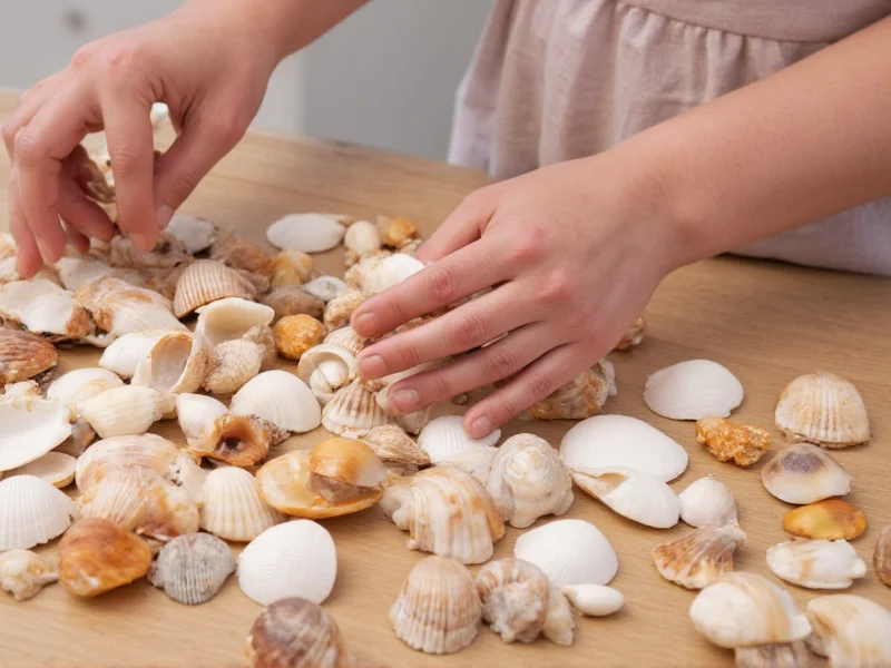 Hand arranging assorted seashells on wooden table for craft project