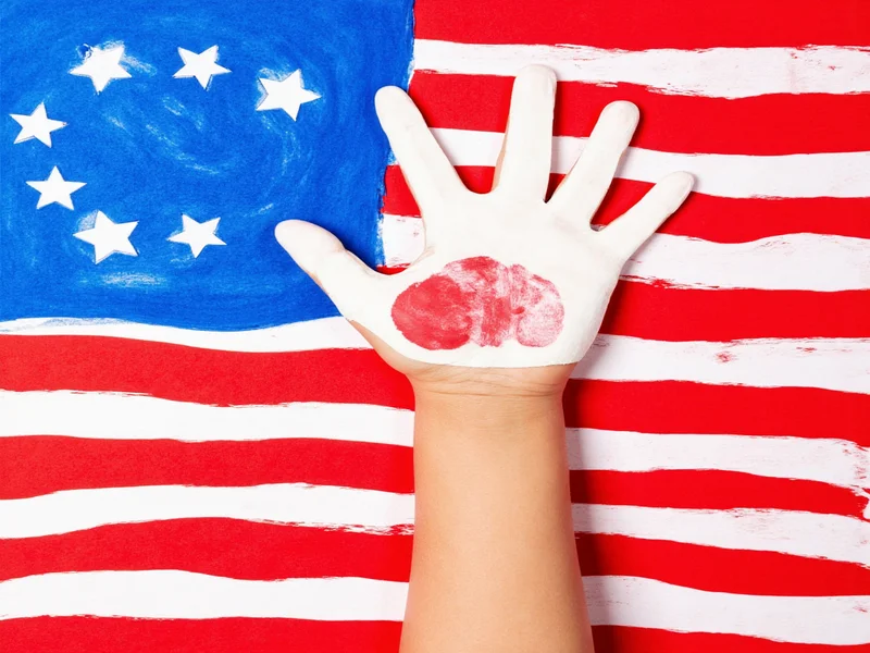 Child's handprint American flag craft on construction paper background