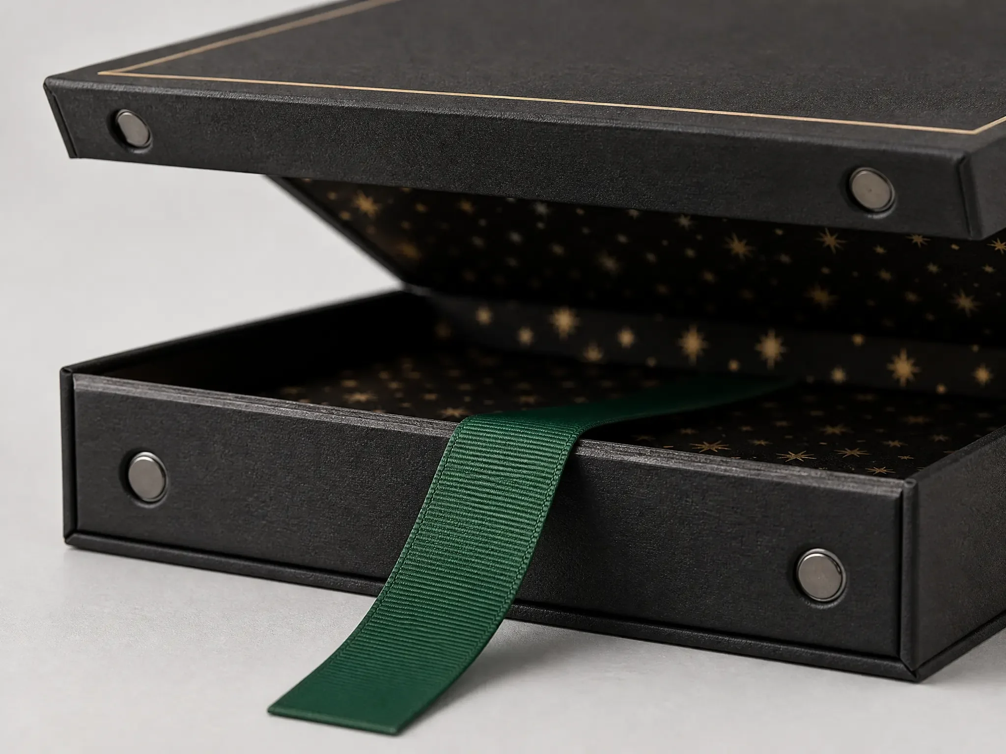 Close-up of a tarot box magnetic closure with two magnets in the lid and base walls plus a green ribbon lift