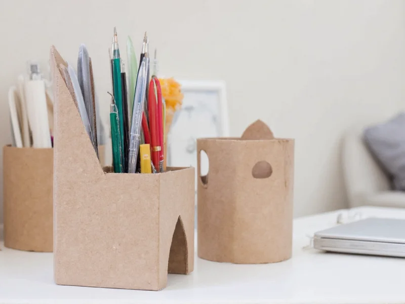 Handmade recycled paper organizer holding pens and scissors on desk