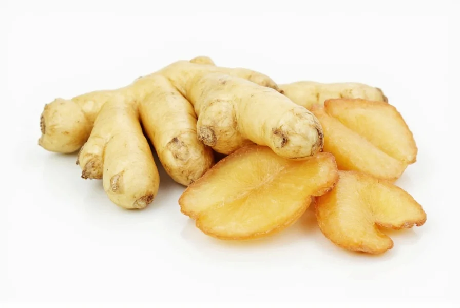 Close-up view of fresh ginger rhizome showing knobby texture and tan skin with yellow interior