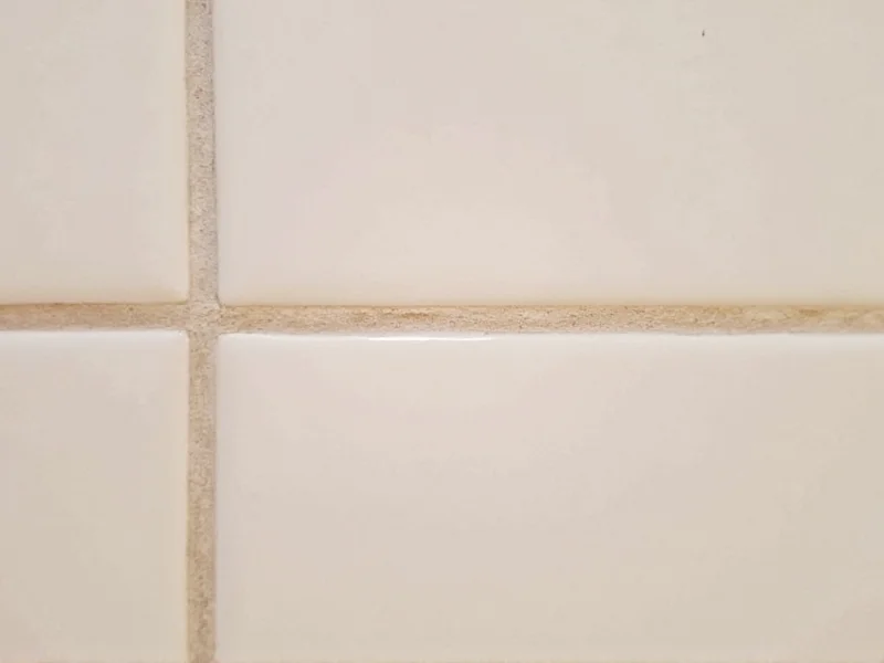 Close-up of stained tile grout lines in bathroom