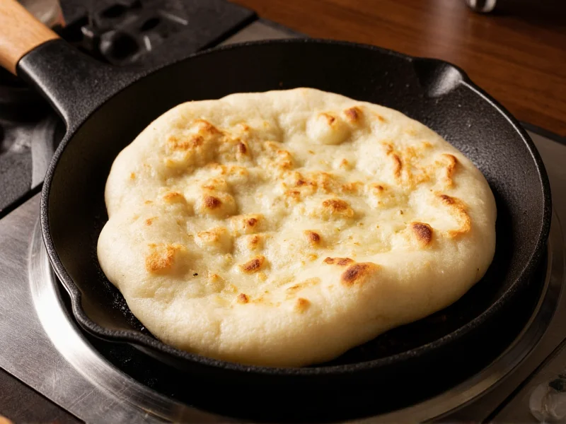 Freshly cooked naan puffed and golden in skillet