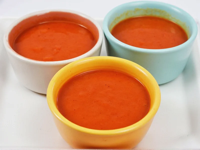 Three tomato soup variations in different colored bowls