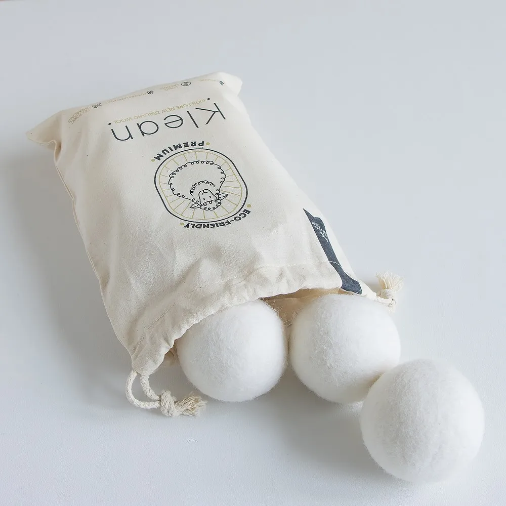 Branded organic cotton drawstring bag with custom printed wool dryer balls spilling out