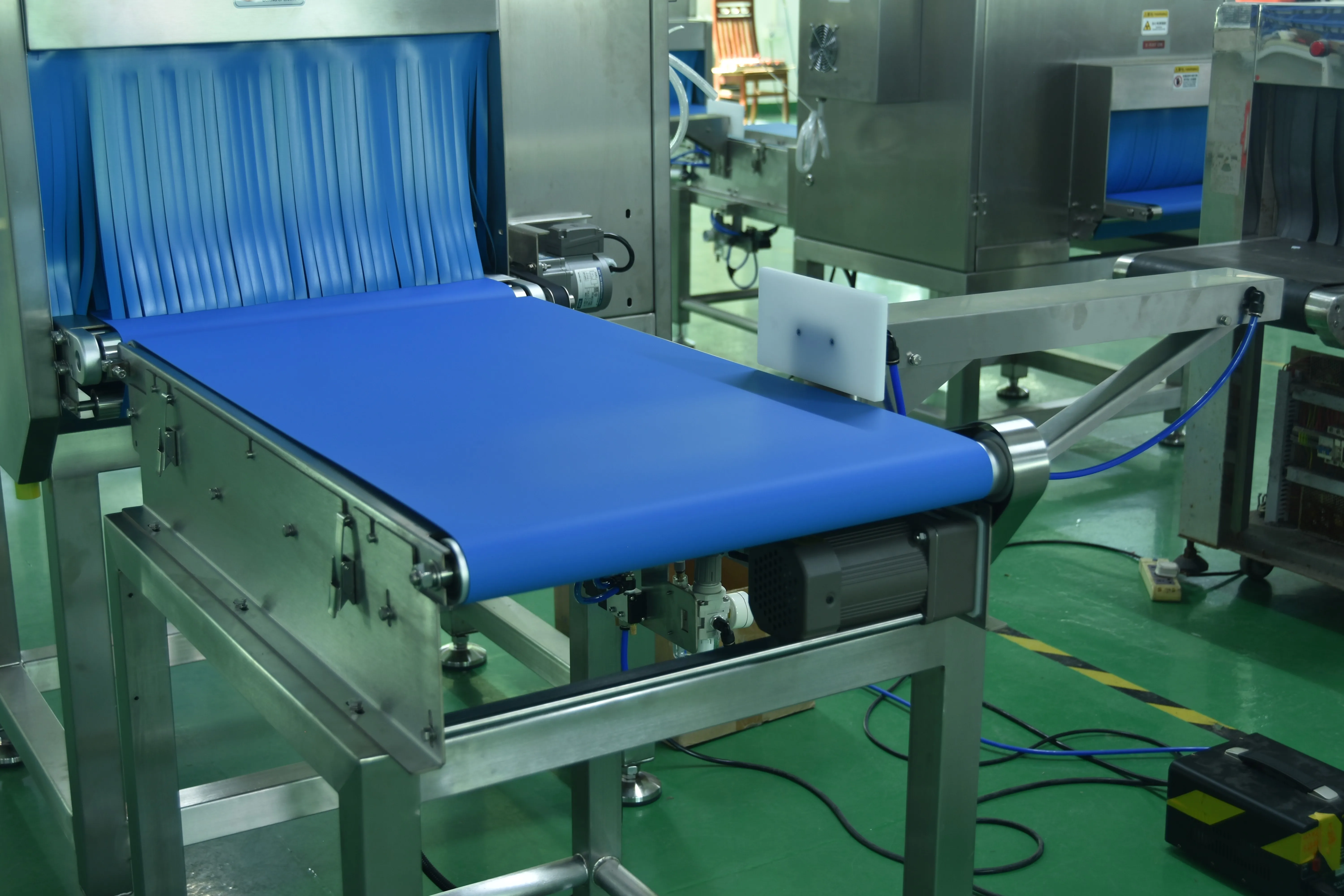 Pneumatic pusher drive and air components under the outfeed conveyor