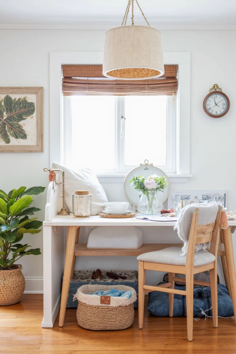 Floating shelves in a cottage bathroom displaying seashells and pinecones in clear jars.