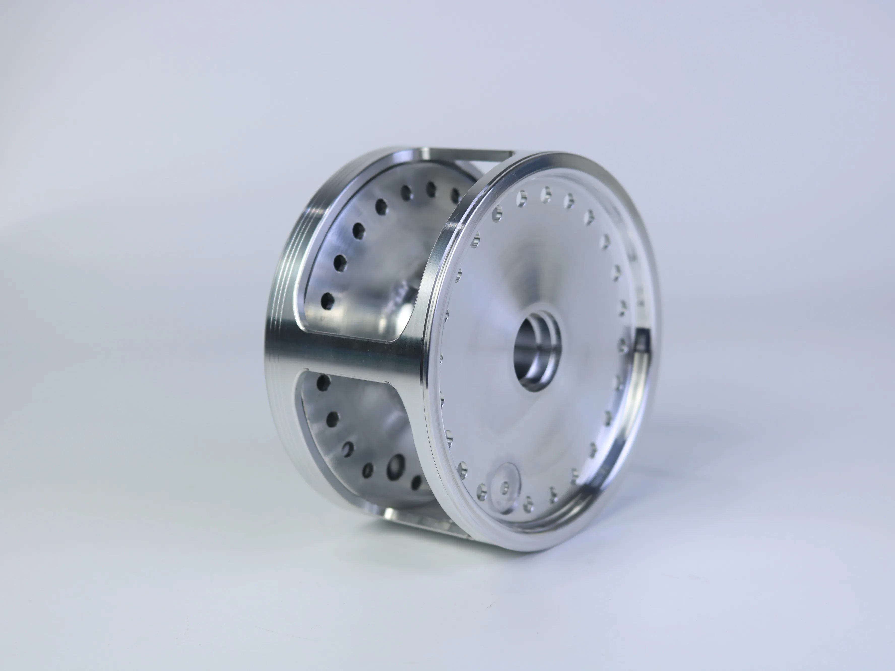 Reflective multi-feature CNC machined cylindrical component with a central opening and repeated internal features