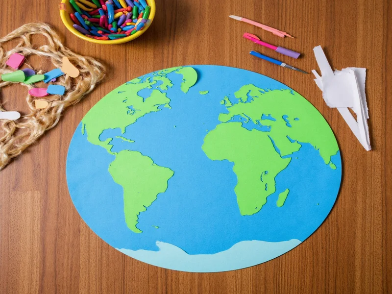 Recycled paper planet map craft materials on wooden table