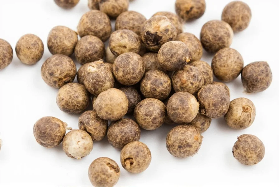 Whole white peppercorns in a grinder