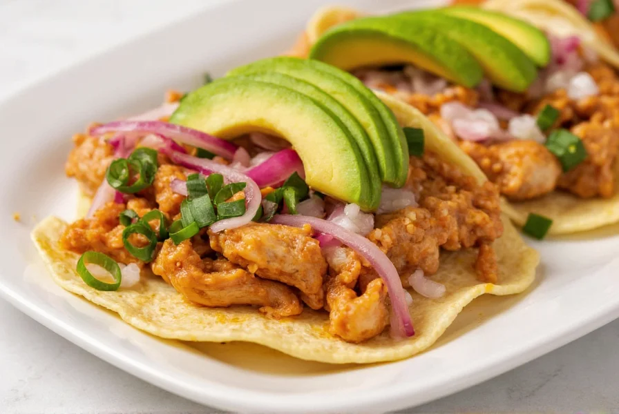 Traditional Mexican chicken tinga served on crispy tostadas with avocado and pickled onions