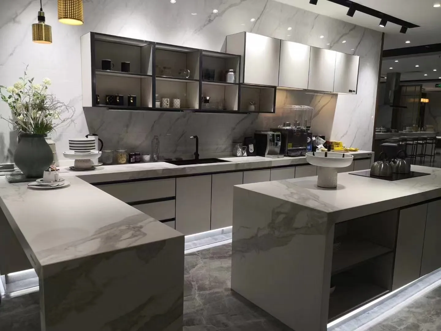 Marble-effect waterfall island with mitred 45-degree edges on display in a kitchen showroom