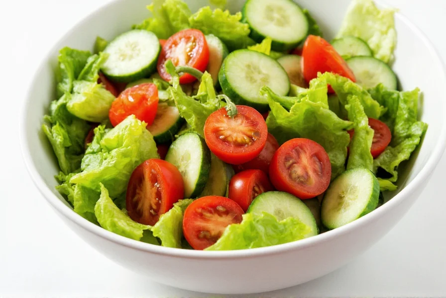 Colorful salad bowl with chopped green bell peppers, tomatoes, cucumbers, and leafy greens