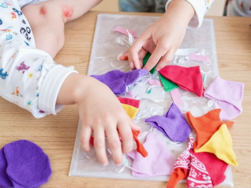 Child's hands creating felt finger puppets with colorful fabric scraps