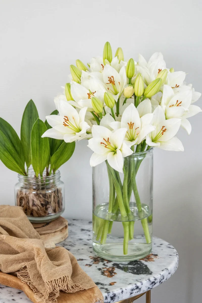 White lily-shaped candle in a glass holder