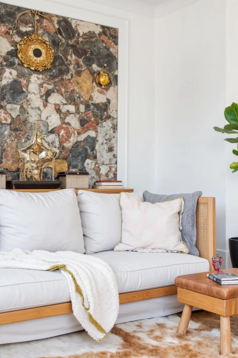 Gray lounge with colorful cushions, rugs, and wall art