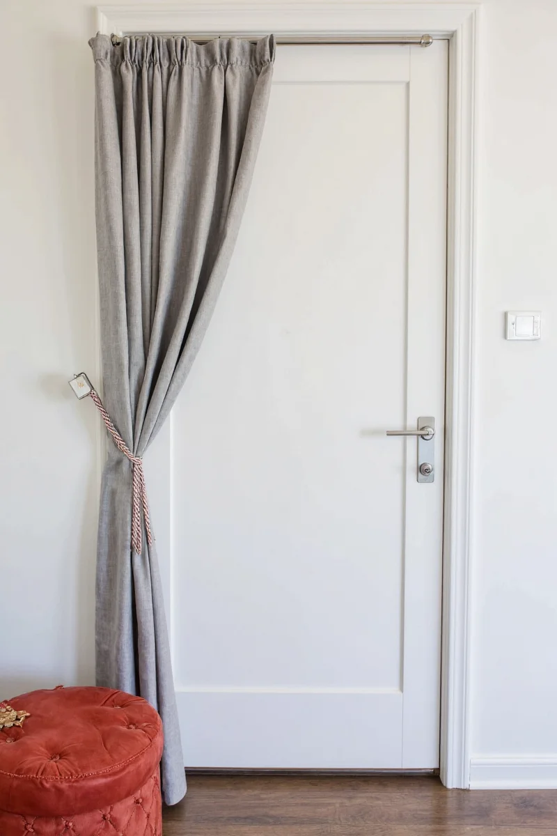 Neutral linen curtain above entryway door