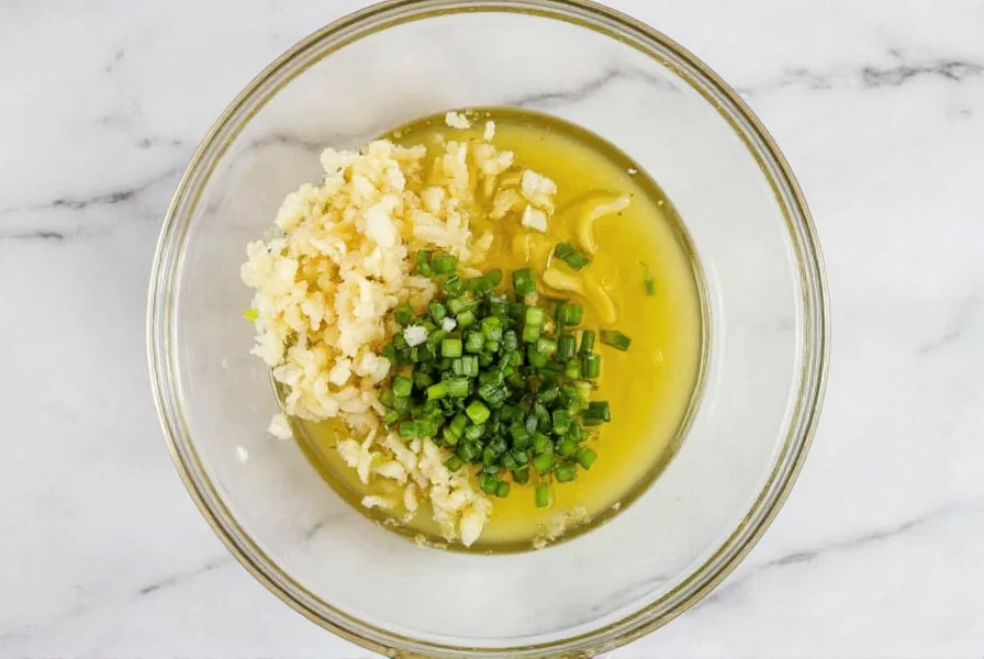 Fresh ginger and scallions finely minced in glass bowl with neutral oil