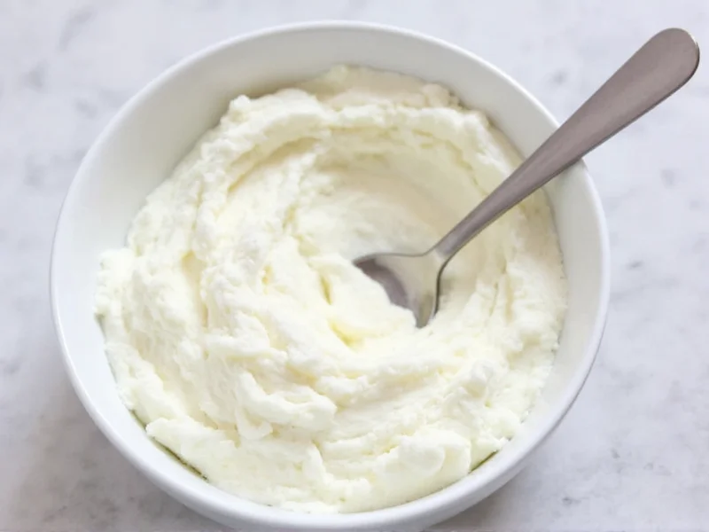 Fresh homemade ricotta cheese in white bowl with spoon