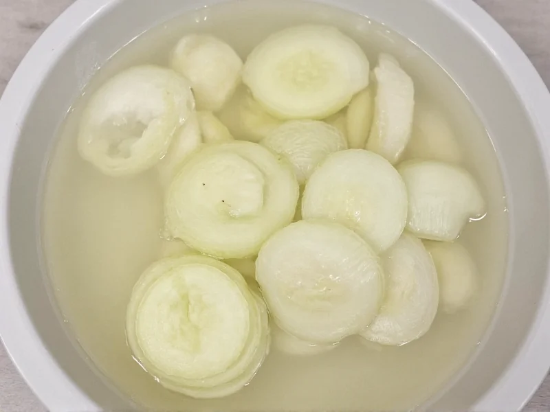 Onion slices soaking in vinegar water solution before frying