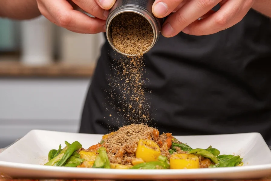 Chef seasoning a dish with pepper meal from a grinder showing the distinctive granule size