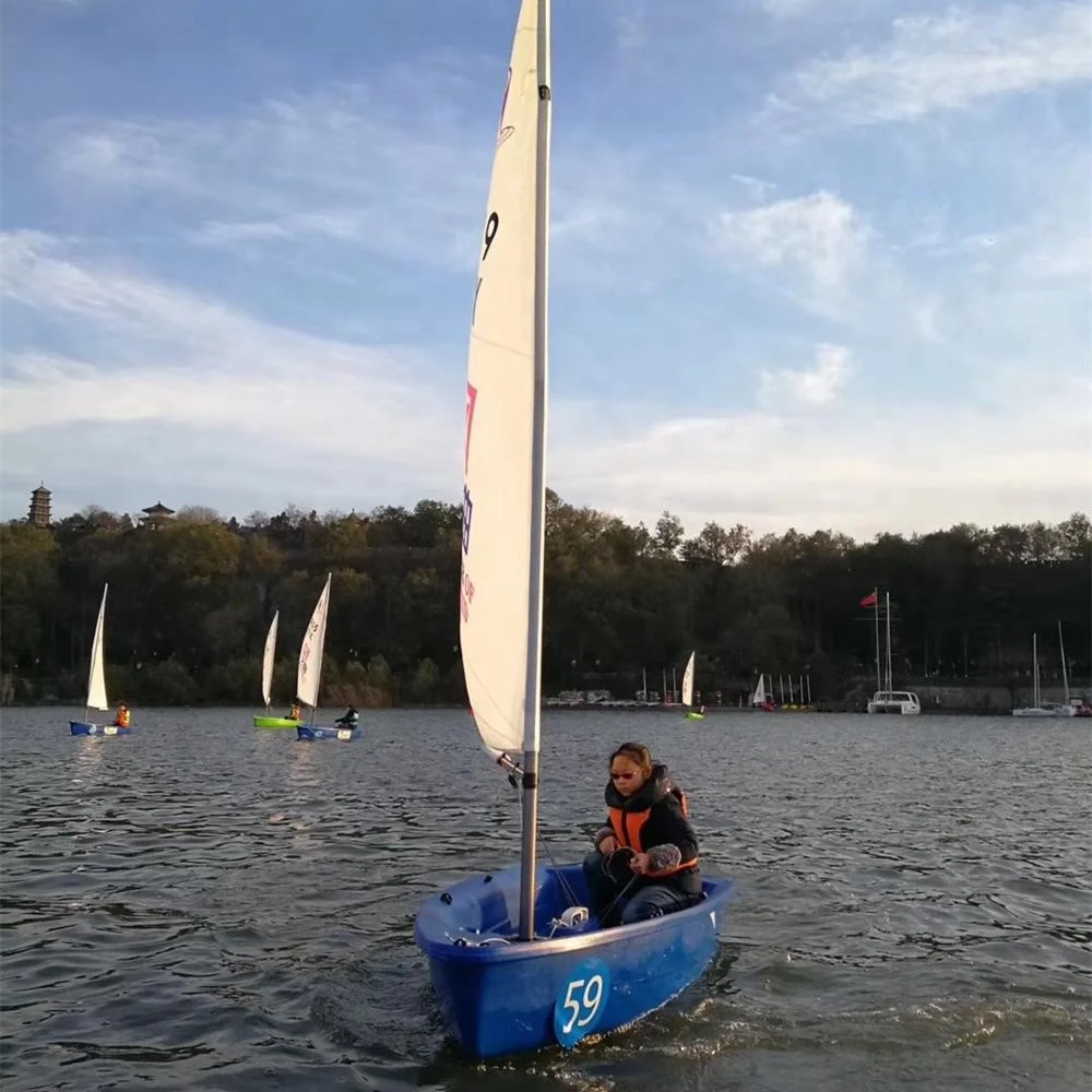 
small optimist student sailboat sails with outrigger 