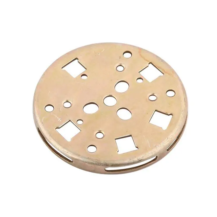 Un buton circular din alamă cu multiple perforații pătrate și rotunde, fotografiat pe un fundal alb simplu.