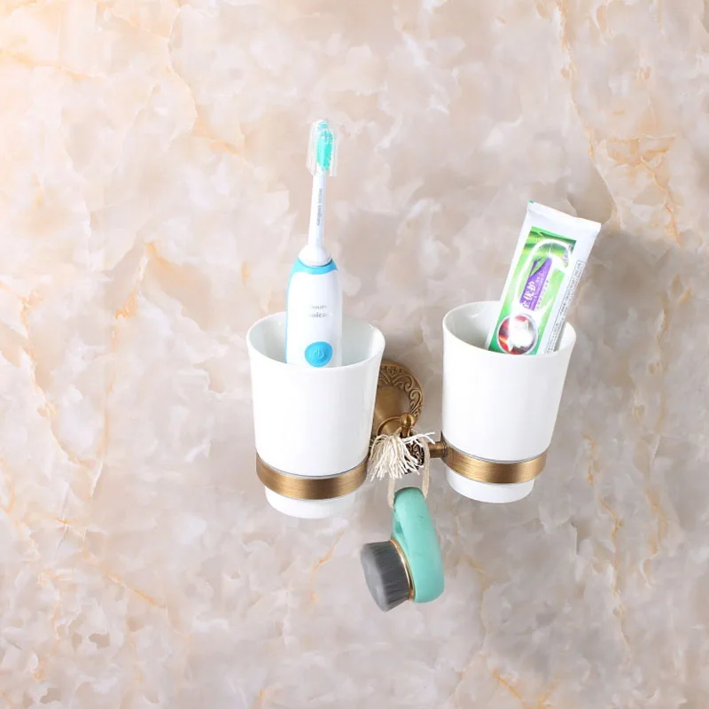 
double antique brass wall mounted cup holder for holding bathroom tool 