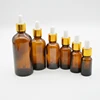 amber essential oil glass dropper bottle with gold top and white rubber