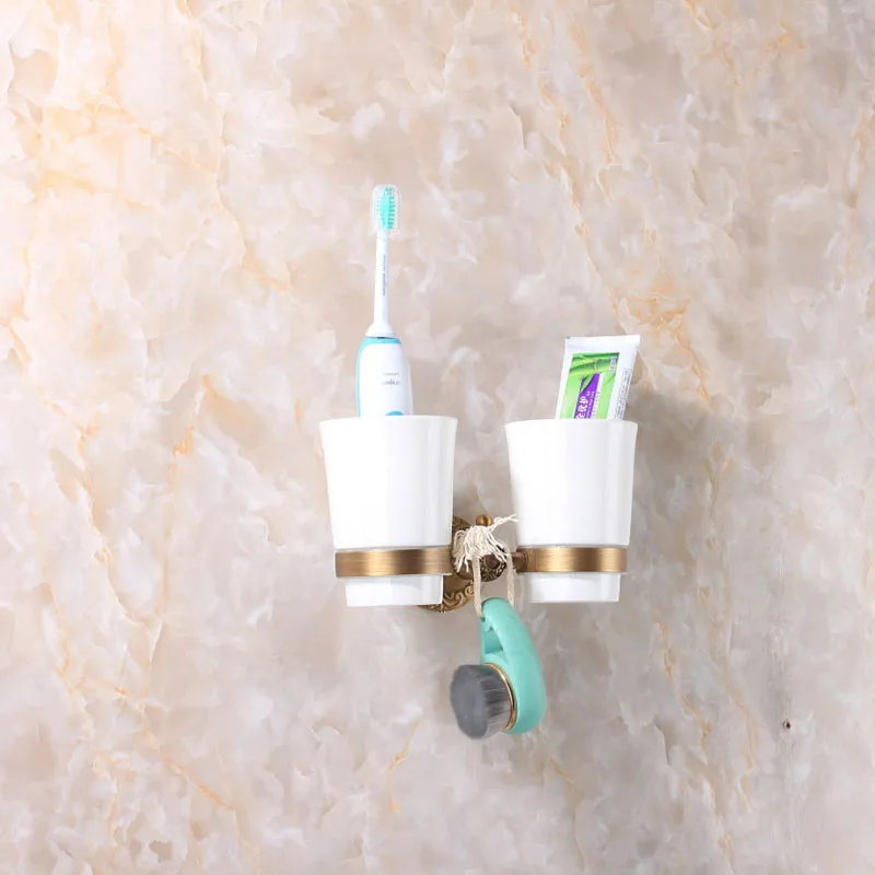 
double antique brass wall mounted cup holder for holding bathroom tool 