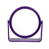 The surface is rounded to form a magnified plastic cosmetic mirror with a solid base