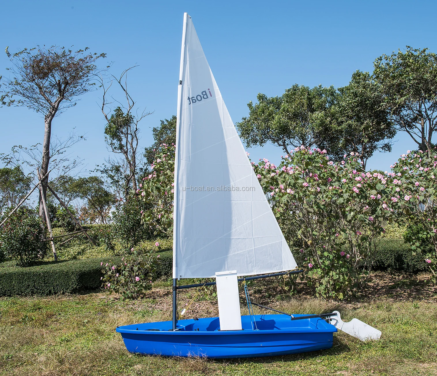 
small optimist student sailboat sails with outrigger 