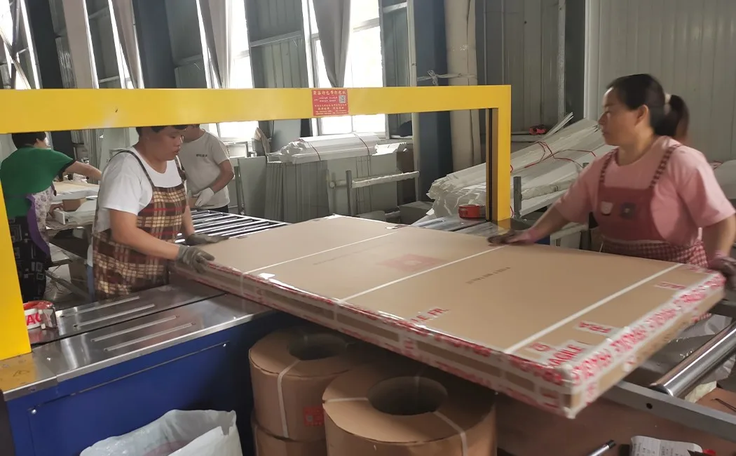 factory workers strapping and sealing flat-pack cartons for steel locker export shipment
