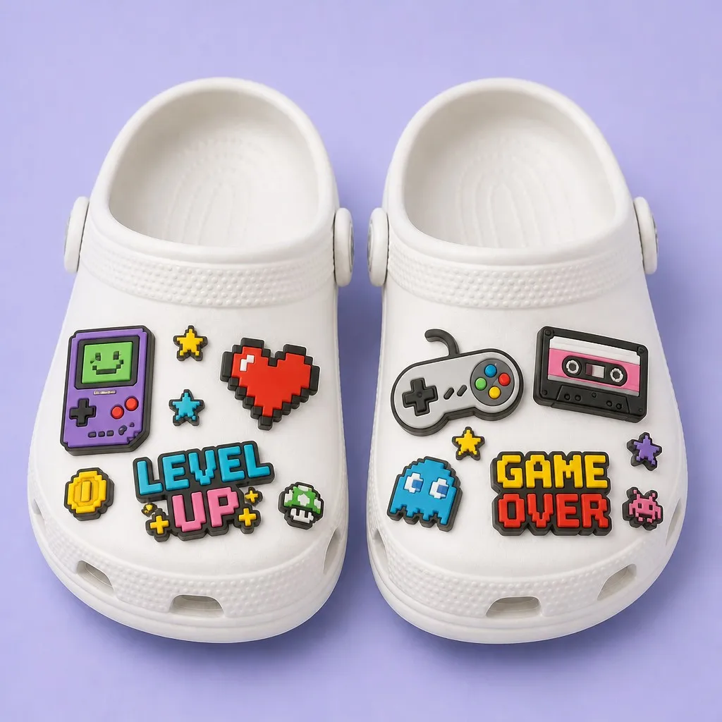 Matched pair of white clogs styled with pixel handhelds, arcade controllers, level badges and retro arcade icons