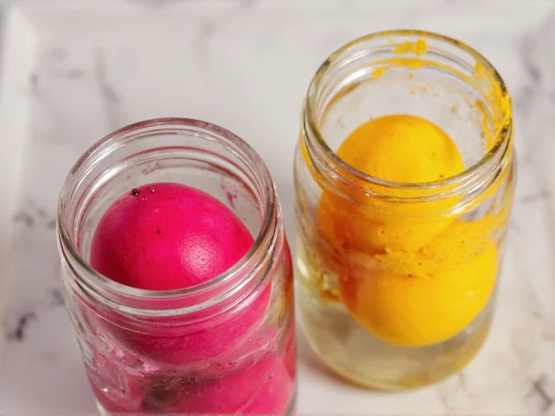 Easter eggs dyed with beetroot and turmeric in mason jars