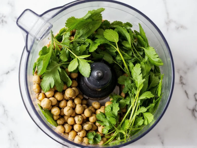 Fresh parsley and cilantro stems in food processor with dried chickpeas