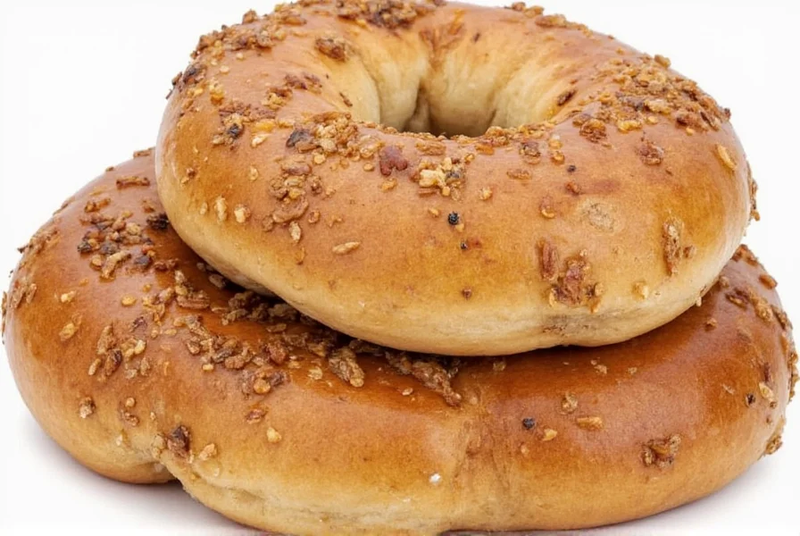 Cinnamon raisin bagel sliced open showing marbled interior with visible cinnamon swirls and raisins, topped with light cream cheese, on rustic wooden table