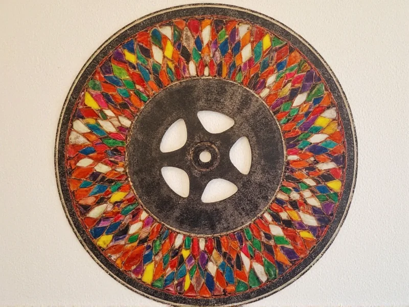 Vintage film reel transformed into colorful wall art with geometric patterns